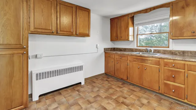 a kitchen with granite countertop a sink window and cabinets