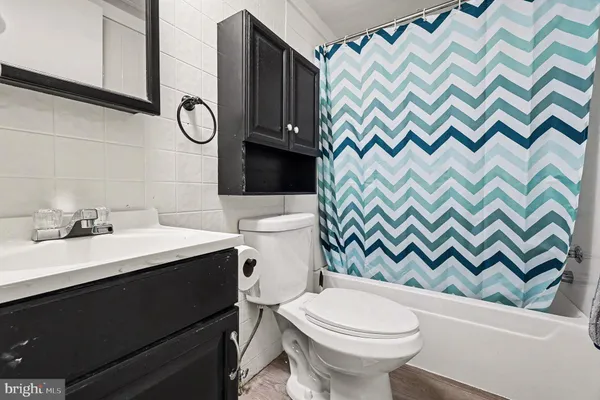 a bathroom with a sink a toilet and a shower curtain