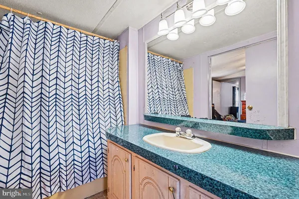 a bathroom with a granite countertop sink and a mirror