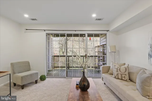 a living room with furniture and a floor to ceiling window