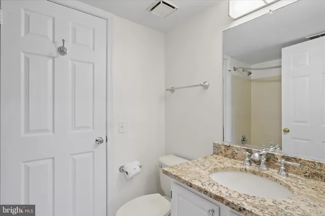 a bathroom with a granite countertop sink toilet and shower