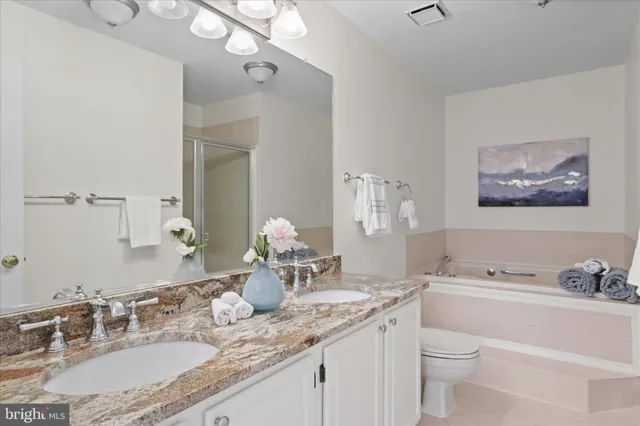 a bathroom with a granite countertop sink mirror and toilet