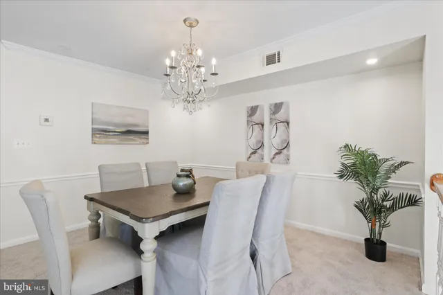 a view of a dining room with furniture and chandelier