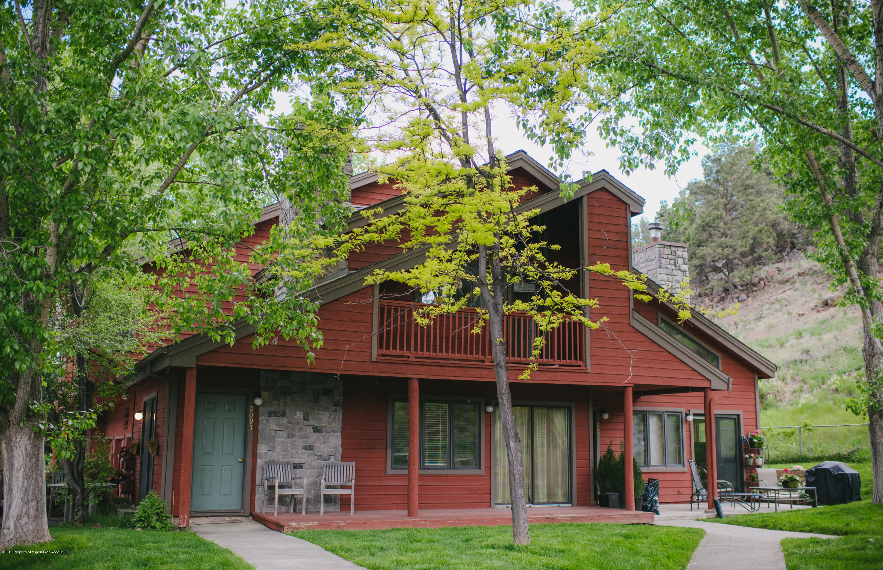 a view of a brick house with a large windows and a large tree