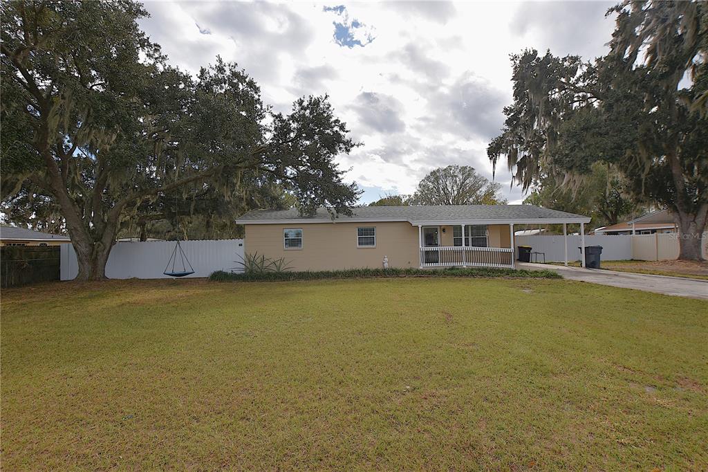 a front view of a house with a large tree and a big yard