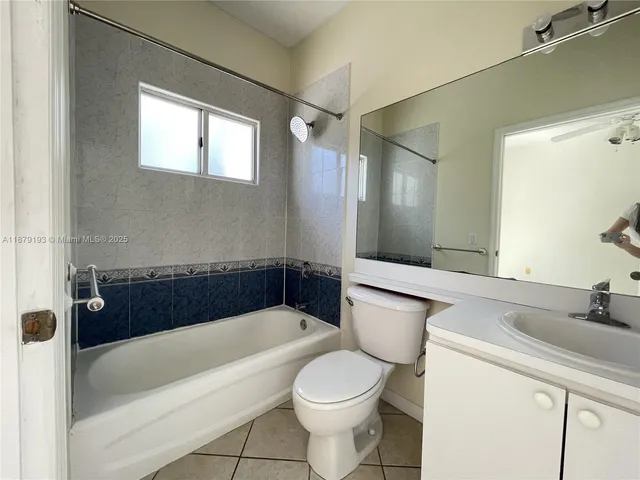 a bathroom with a sink a toilet a mirror a bathtub and shower