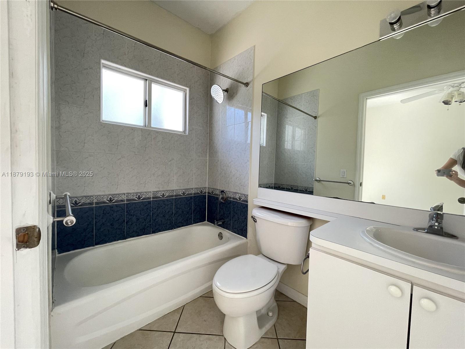2734 Bird Avenue, Unit 205 Miami, FL 33133 - Photo 12 of 20 a bathroom with a sink a toilet a mirror a bathtub and shower