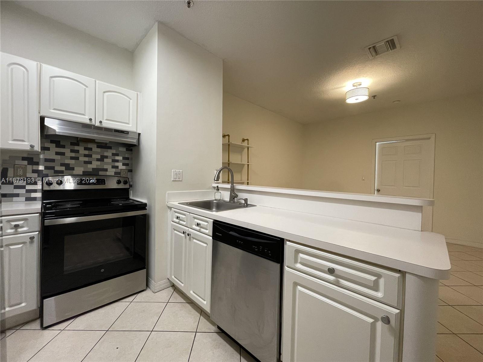 2734 Bird Avenue, Unit 205 Miami, FL 33133 - Photo 2 of 20 a kitchen with cabinets stainless steel appliances and sink