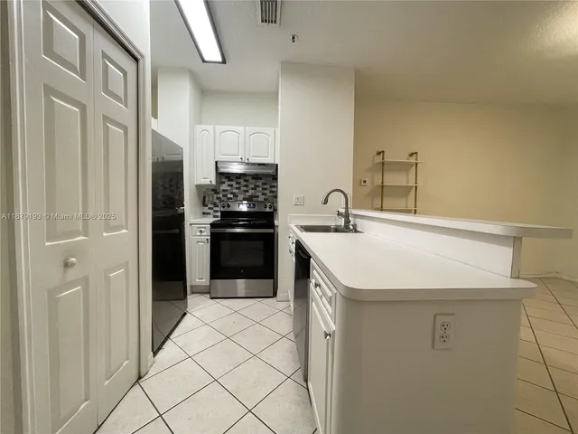a kitchen with a sink a refrigerator and cabinets