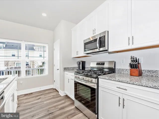 a kitchen with stainless steel appliances granite countertop a stove and a microwave