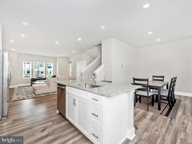 a kitchen with granite countertop a stove sink microwave and refrigerator