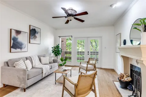 a living room with furniture a fireplace and a large window