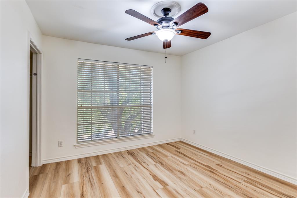 8555 Fair Oaks Crossing, Unit 702 Dallas, TX 75243 - Photo 20 of 26 an empty room with wooden floor chandelier fan and windows