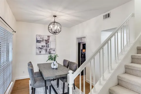 a view of a dining room with furniture a chandelier and wooden floor