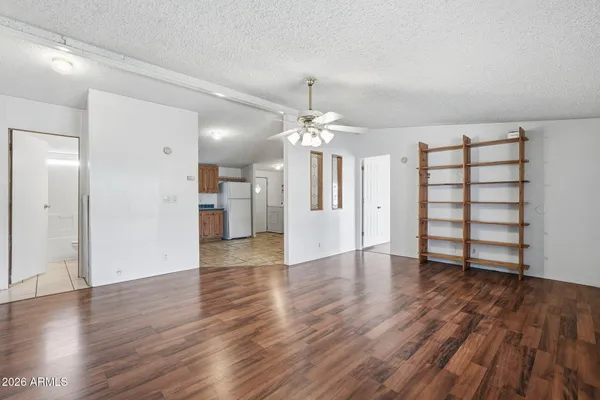a view of a kitchen with wooden floor and a refrigerator
