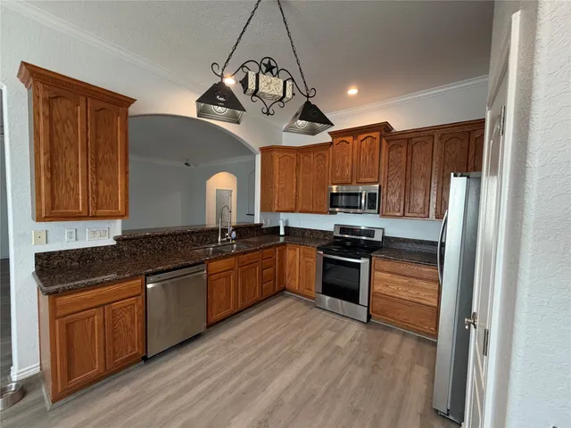 a kitchen with granite countertop stainless steel appliances and wooden cabinets