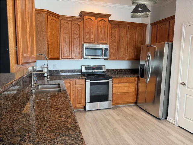 a kitchen with a refrigerator sink and cabinets