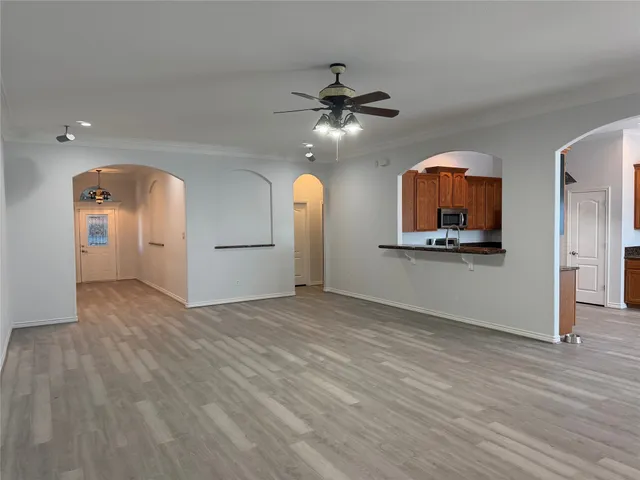 a view of a kitchen with wooden floor and a ceiling fan