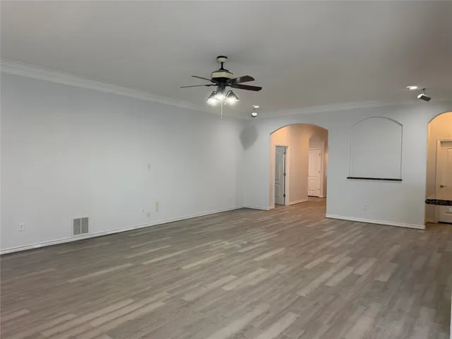 wooden floor in an empty room with a ceiling fan