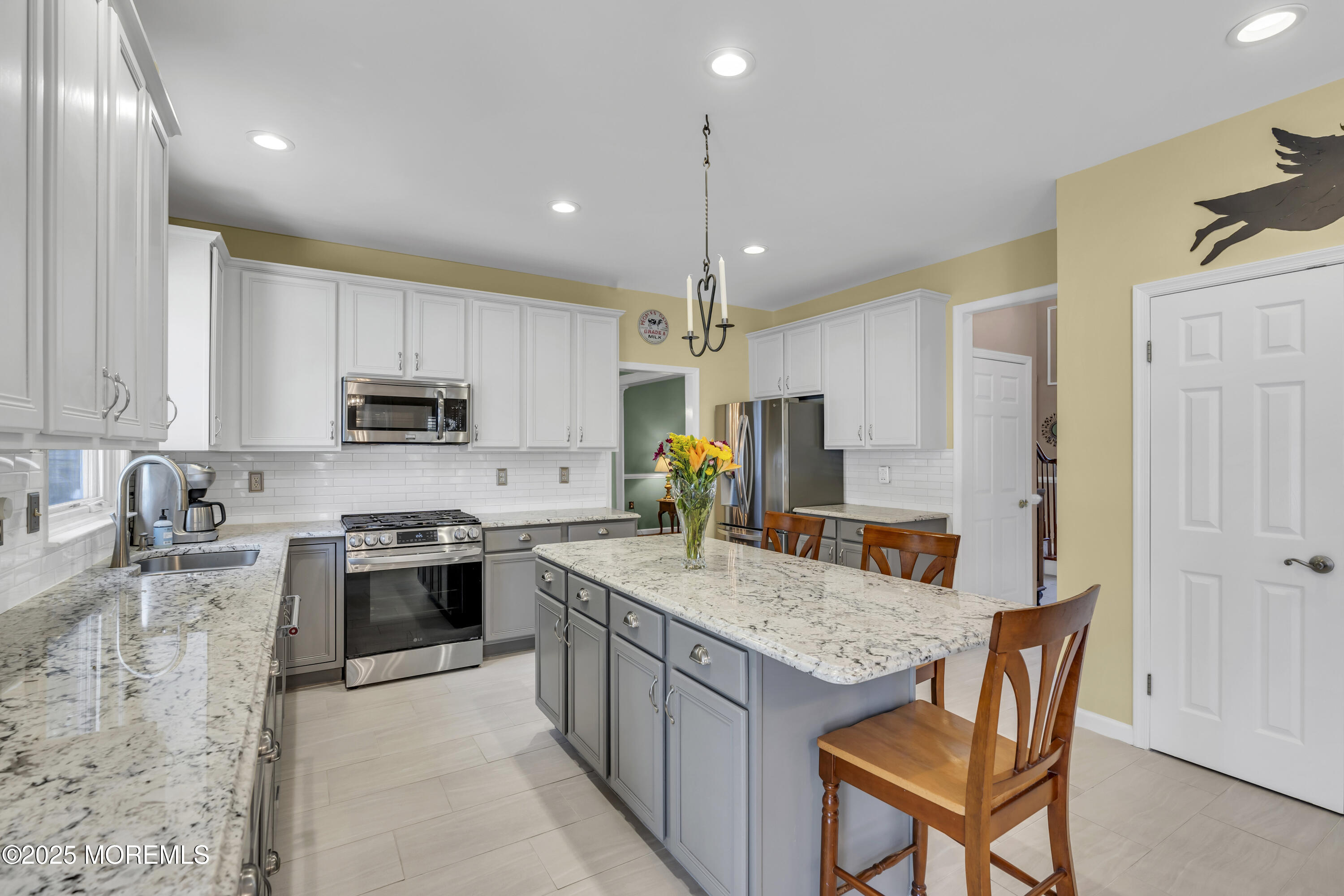 43 Periwinkle Circle Tinton Falls, NJ 07712 - Photo 21 of 60 a kitchen with stainless steel appliances granite countertop a stove top oven a sink dishwasher a dining table and chairs with wooden floor