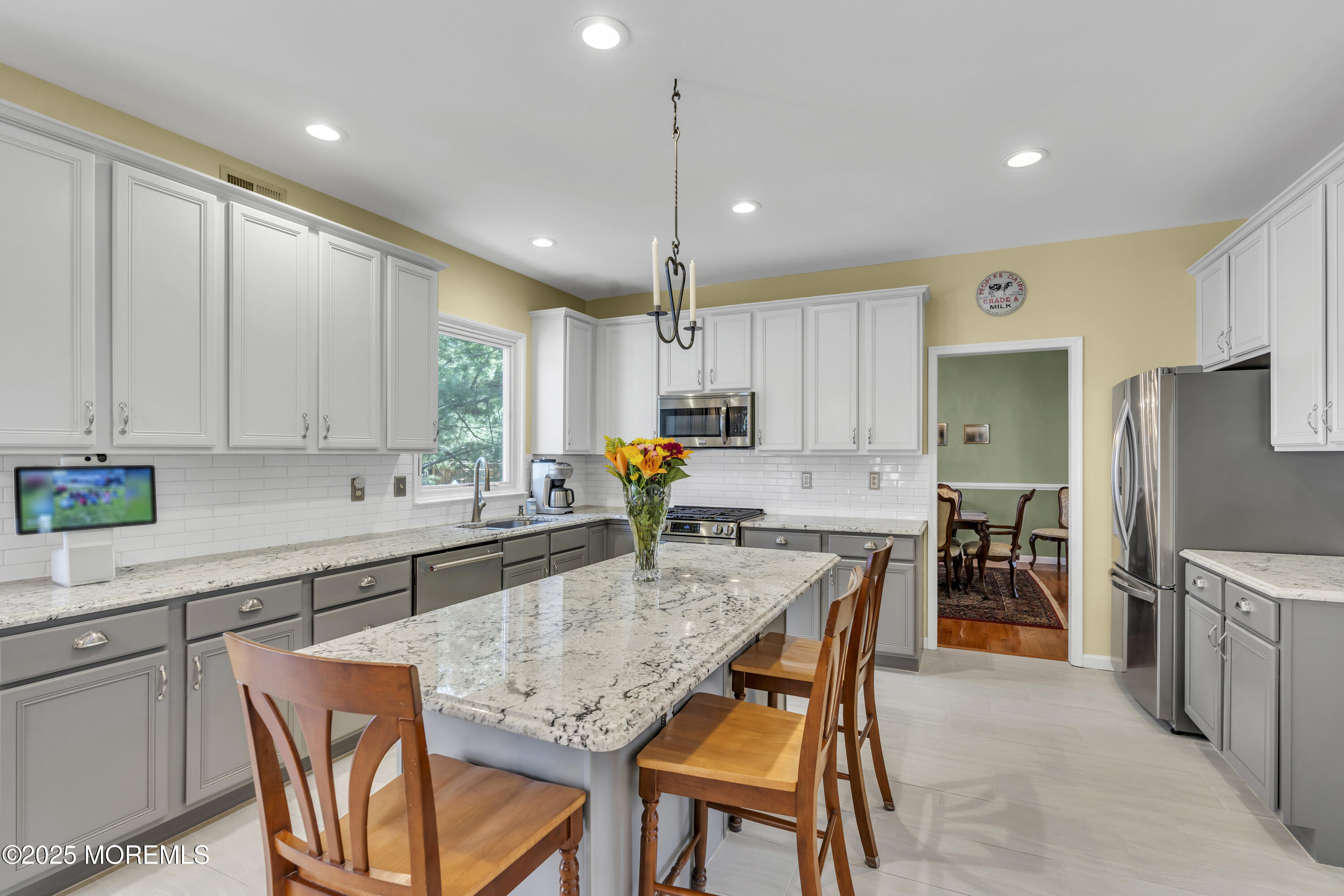 43 Periwinkle Circle Tinton Falls, NJ 07712 - Photo 22 of 60 a kitchen with granite countertop a table chairs microwave and refrigerator