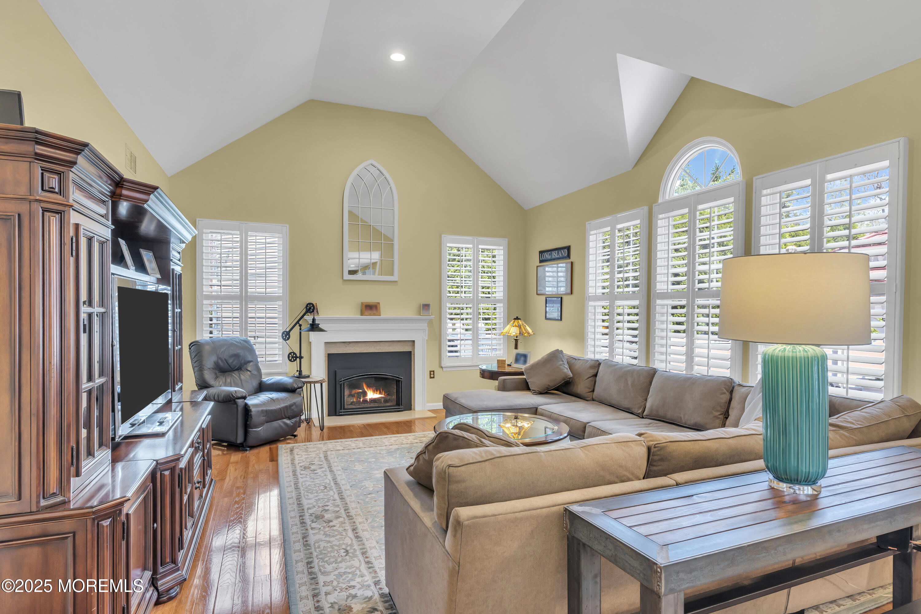 43 Periwinkle Circle Tinton Falls, NJ 07712 - Photo 27 of 60 a living room with furniture a fireplace and a flat screen tv
