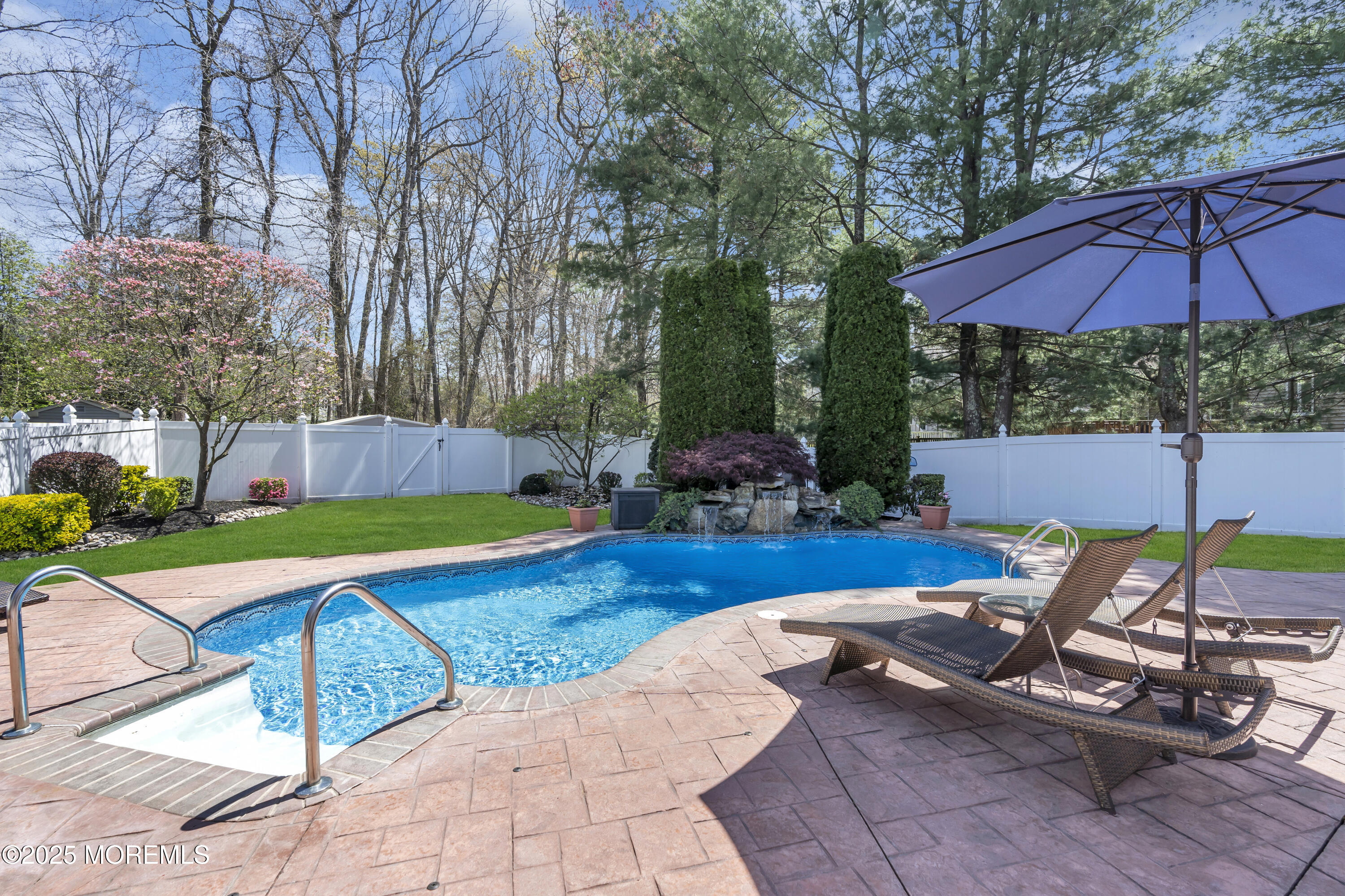 43 Periwinkle Circle Tinton Falls, NJ 07712 - Photo 54 of 60 a view of pool with lawn chairs under an umbrella