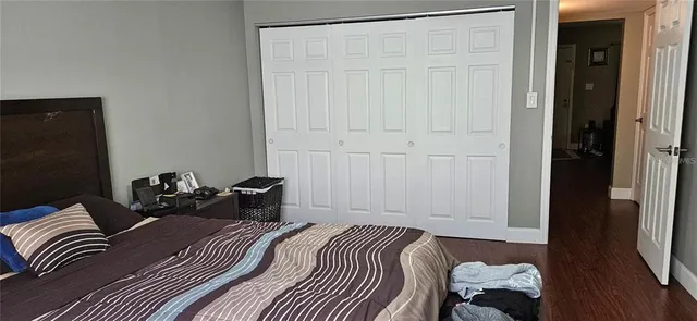 a bedroom with a bed and wooden floor