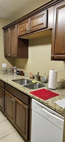 a utility room with granite countertop cabinets and sink