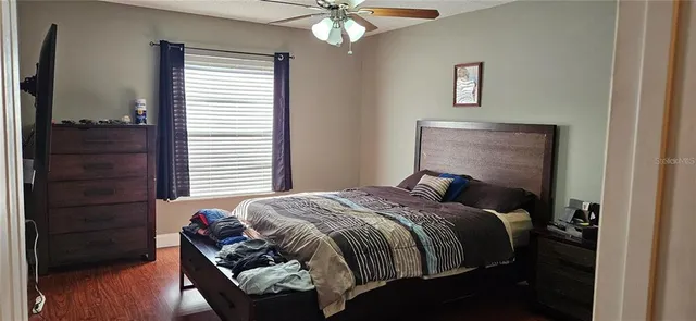 a bedroom with a bed and wooden floor