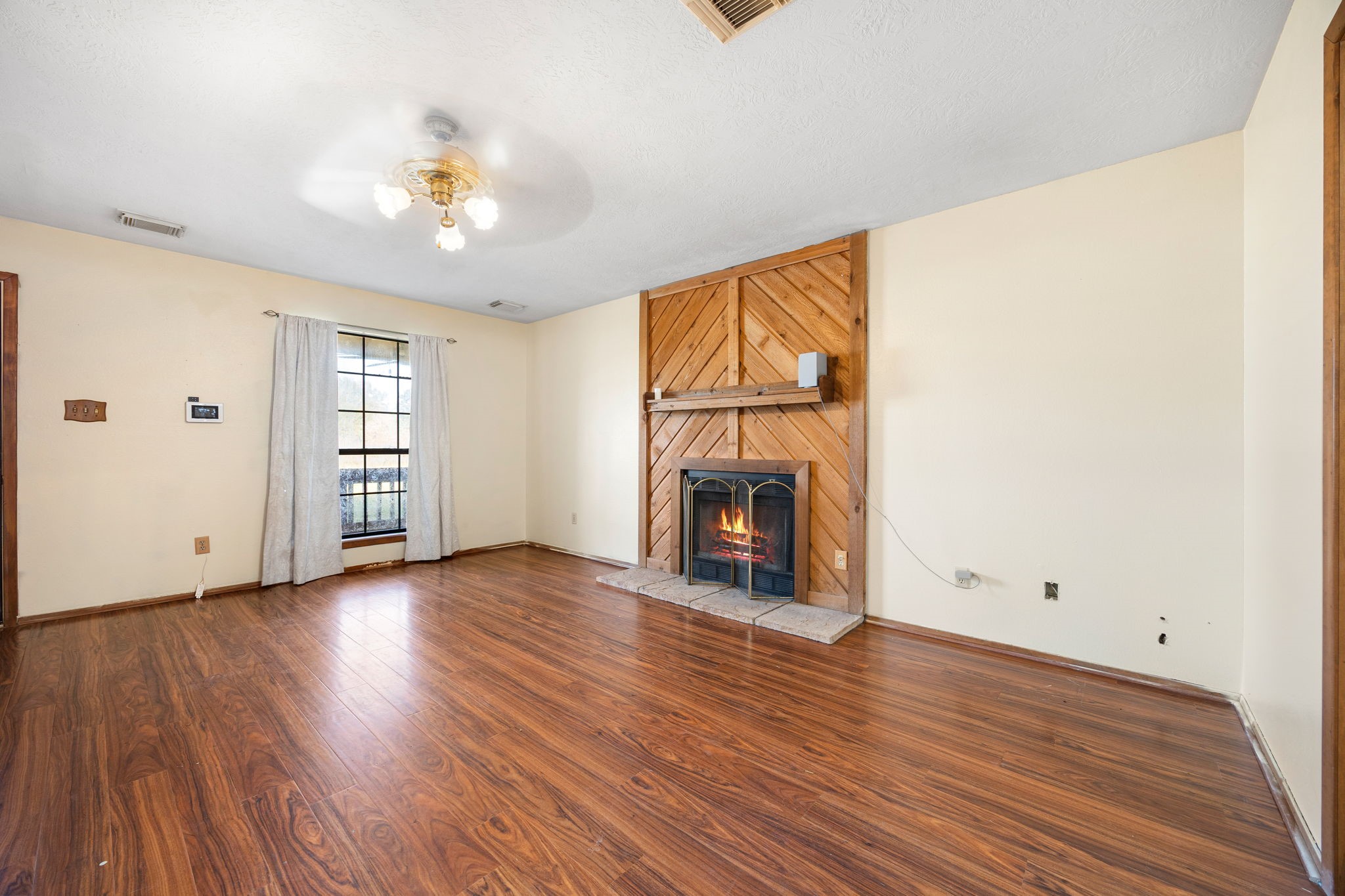 236 Pine Ridge Drive Cleveland, TX 77327 - Photo 5 of 30 an empty room with wooden floor chandelier fan and windows
