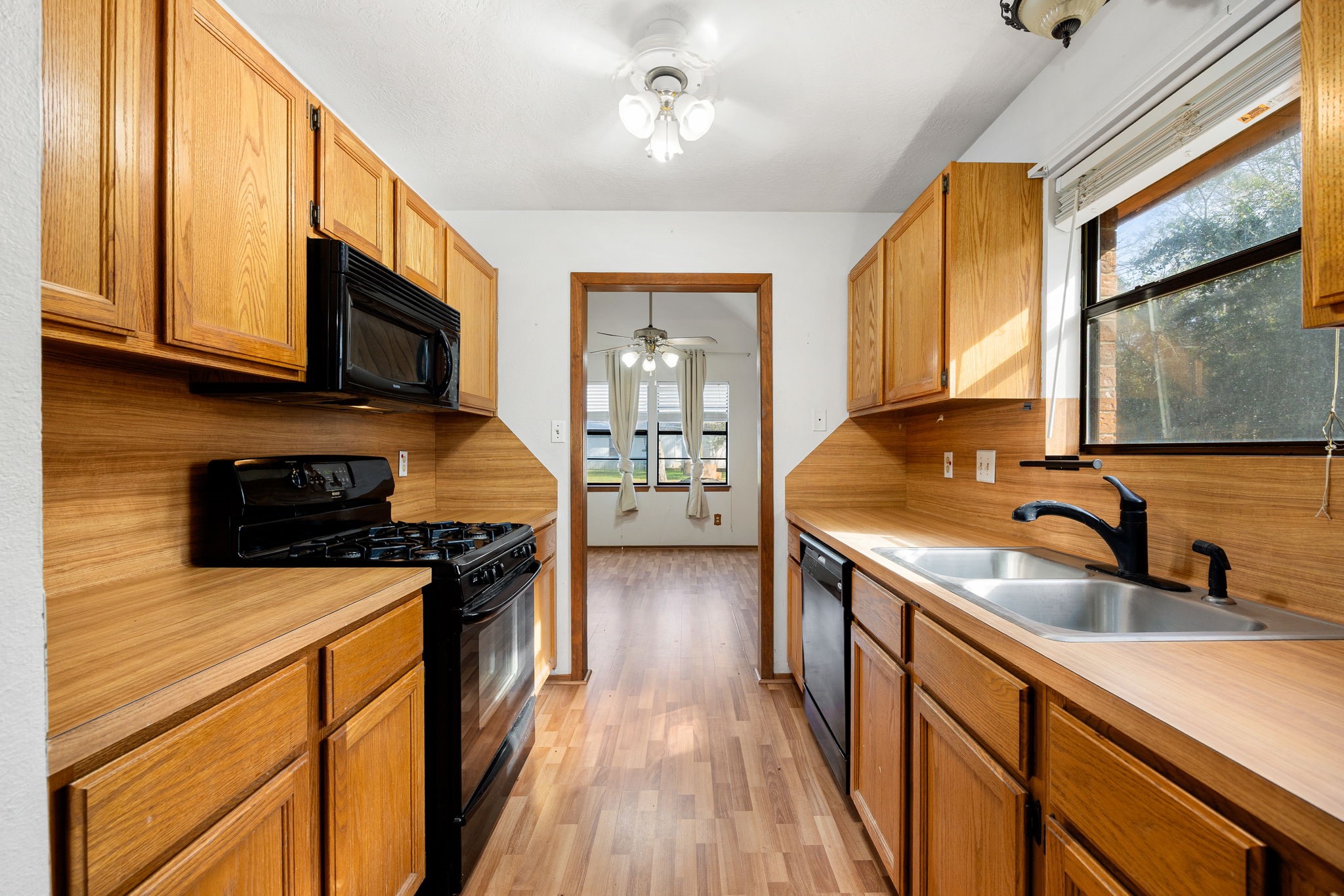 236 Pine Ridge Drive Cleveland, TX 77327 - Photo 10 of 30 a kitchen with stainless steel appliances a stove sink microwave and cabinets