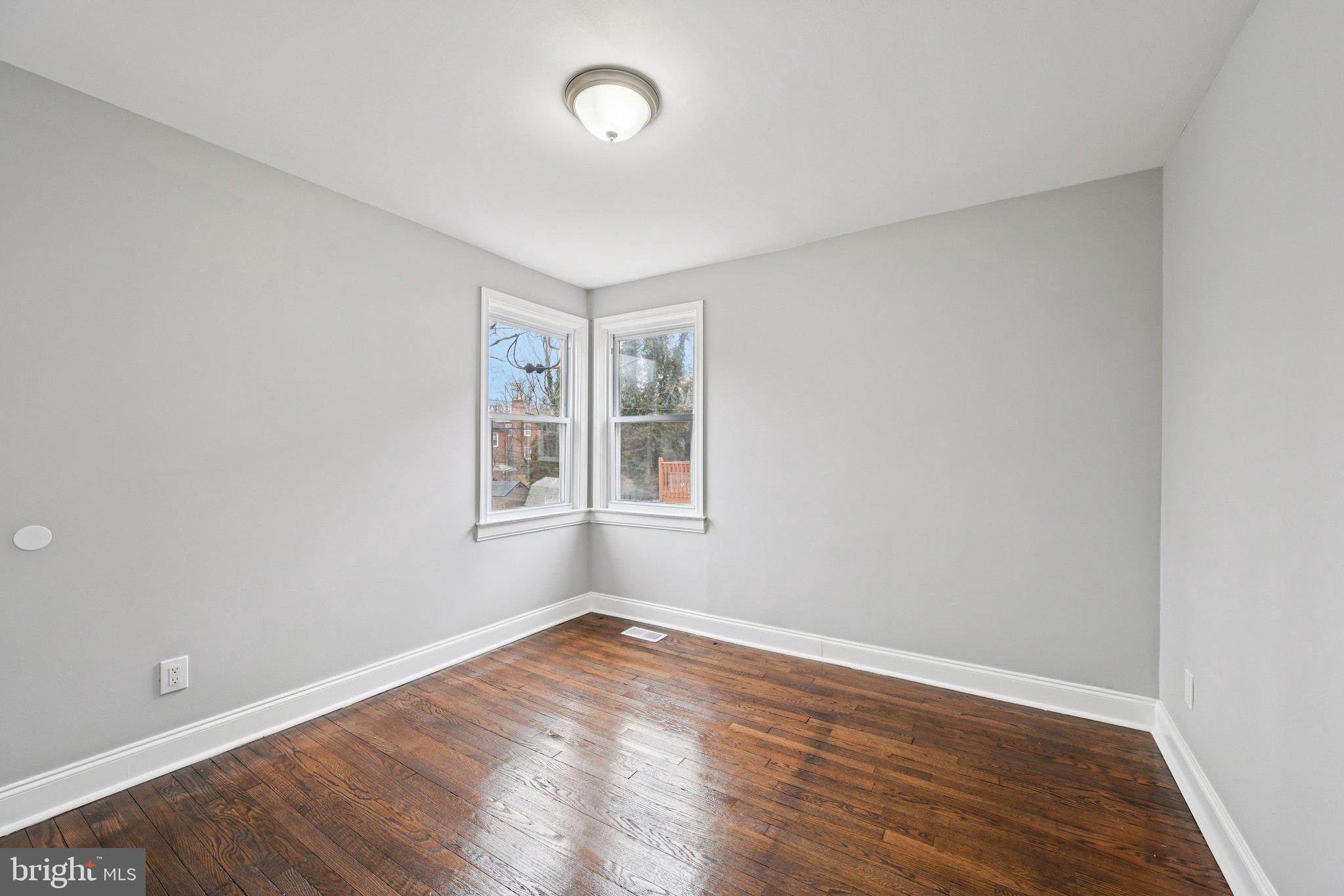 4902 Gilray Drive Baltimore, MD 21214 - Photo 21 of 54 an empty room with wooden floor and windows