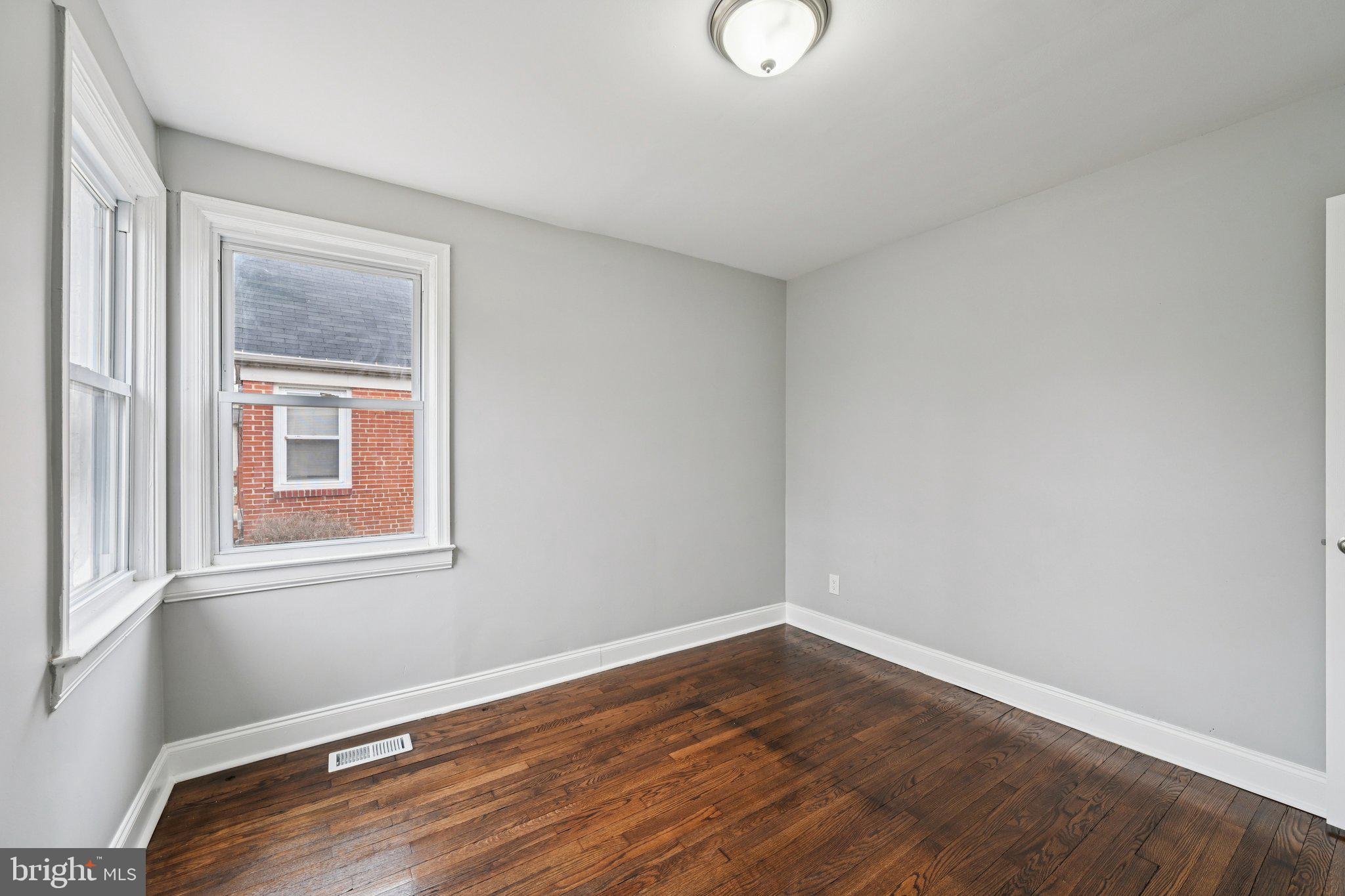 4902 Gilray Drive Baltimore, MD 21214 - Photo 23 of 54 a view of an empty room with wooden floor and a window