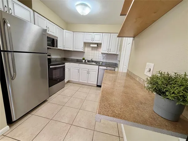 a kitchen with stainless steel appliances granite countertop a refrigerator and a sink