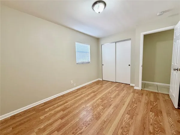 a view of empty room with wooden floor