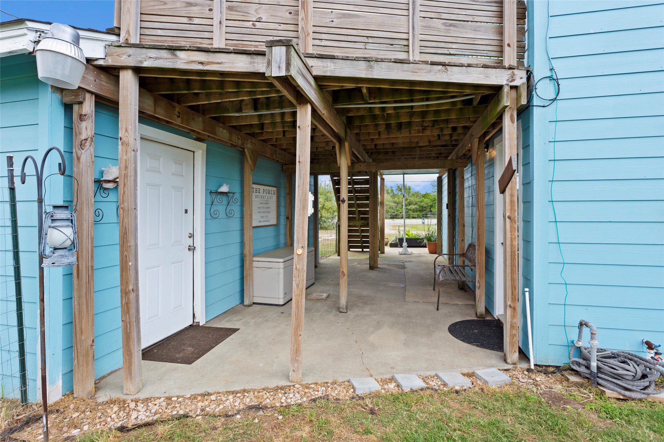 1619 FM 517 Road East San Leon, TX 77539 - Photo 20 of 27 Covered outdoor area downstairs supported by wooden beams and entry into garage.