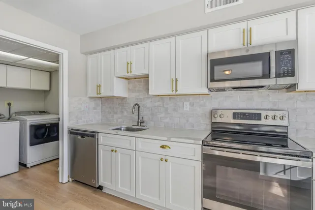 a kitchen with appliances a sink and cabinets