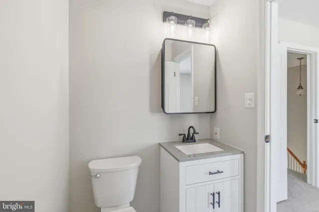 a bathroom with a toilet sink and mirror