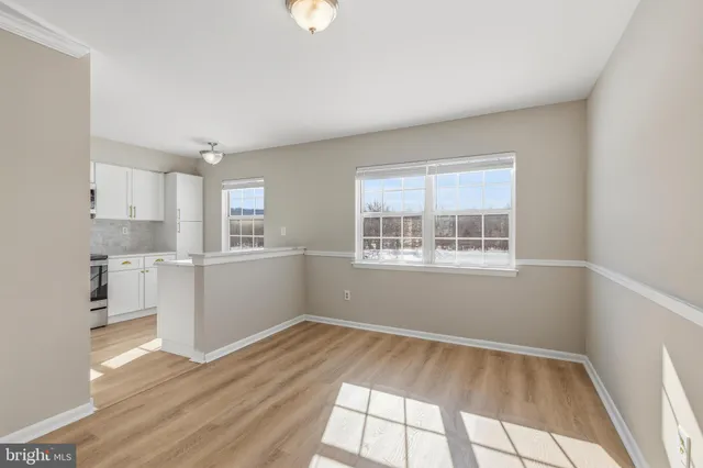 a view of a kitchen with wooden floor and electronic appliances