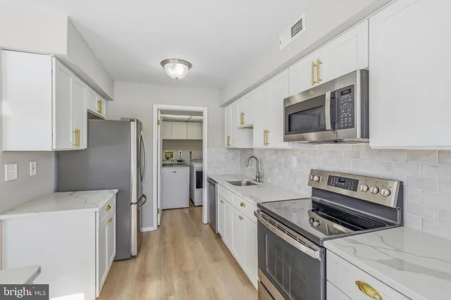 a kitchen with stainless steel appliances a stove microwave and a refrigerator