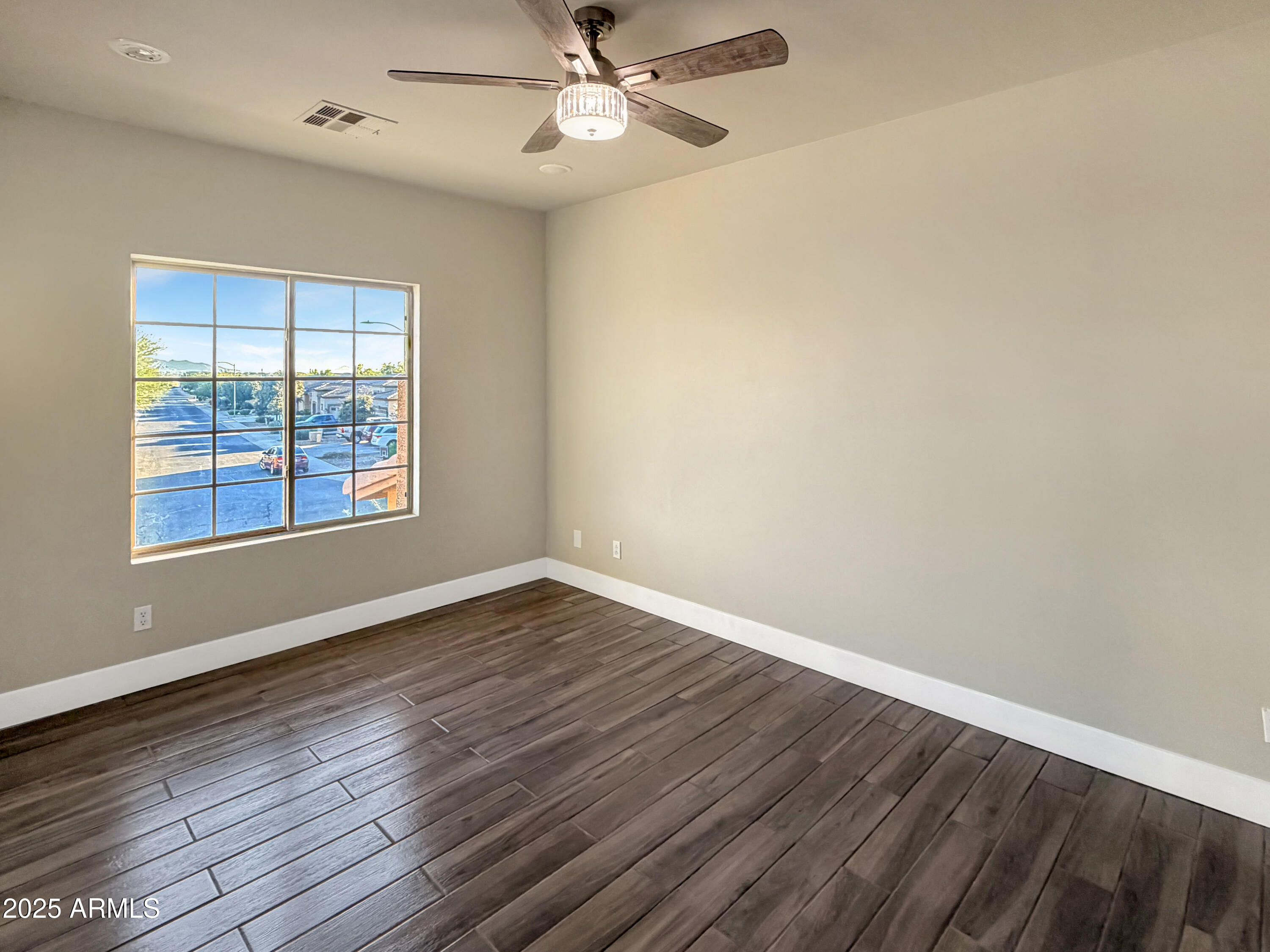 1712 East Joelle Drive Casa Grande, AZ 85122 - Photo 37 of 55 a view of an empty room with wooden floor and a window