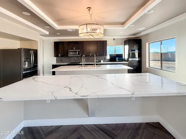 a large kitchen with kitchen island granite countertop a sink a stove and cabinets