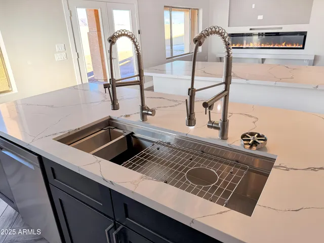a large kitchen with cabinets a counter and chairs