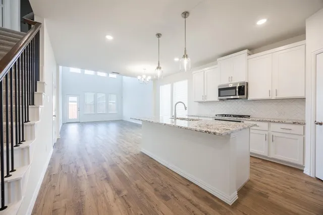a kitchen with kitchen island granite countertop a sink appliances cabinets and counter space