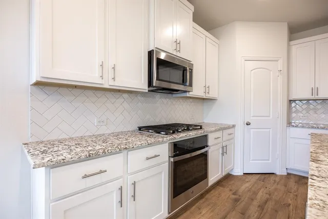a kitchen with granite countertop a stove and a sink