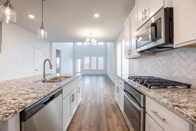 a view of a kitchen with kitchen island wooden floor and center island