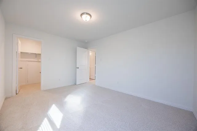 a spacious bedroom with a bed and a dresser