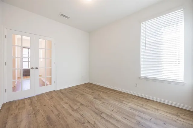a view of a hallway with wooden floor and closet