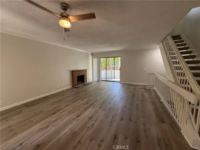 a view of empty room with wooden floor and fireplace
